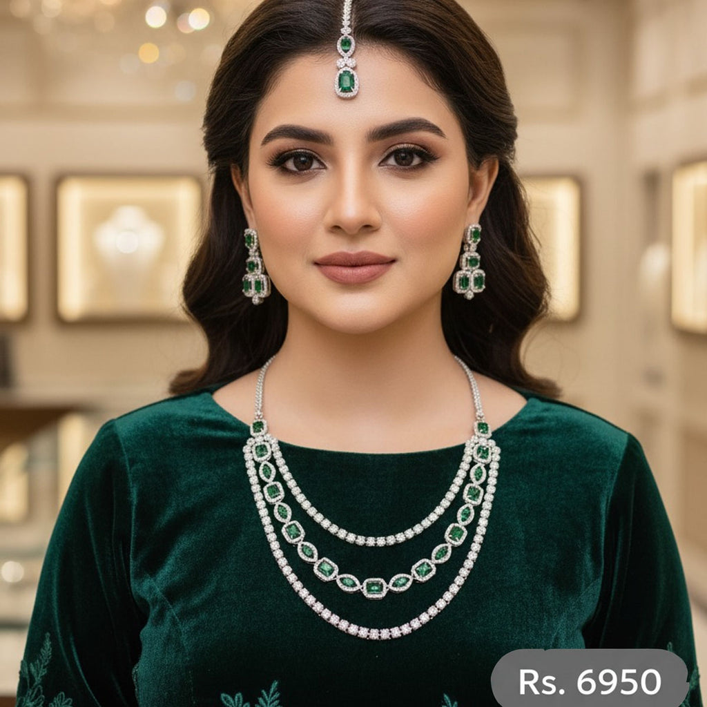 Emerald green bridal jewelry set with layered necklace, earrings, and tikka