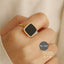 Gold-tone minimalist ring with black square face on hand – Destiny.pk.