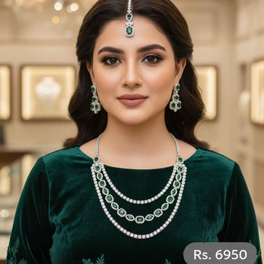 Emerald green bridal jewelry set with layered necklace, earrings, and tikka