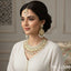Gold-plated bridal jewelry set with Kundan stones and pearls, including a necklace, jhumka earrings, and tikka, priced at Rs. 12500