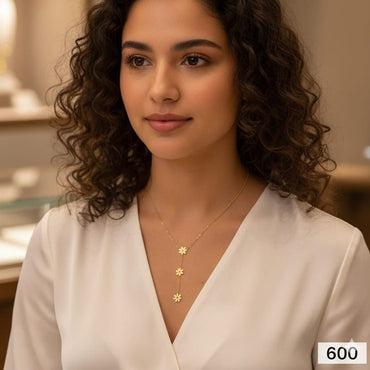 Dainty gold lariat necklace with delicate flower charm, priced Rs. 600