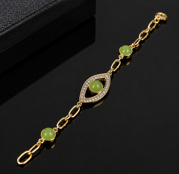 Elegant gold-tone green stone link bracelet with crystal-detailed eye-shaped centerpiece