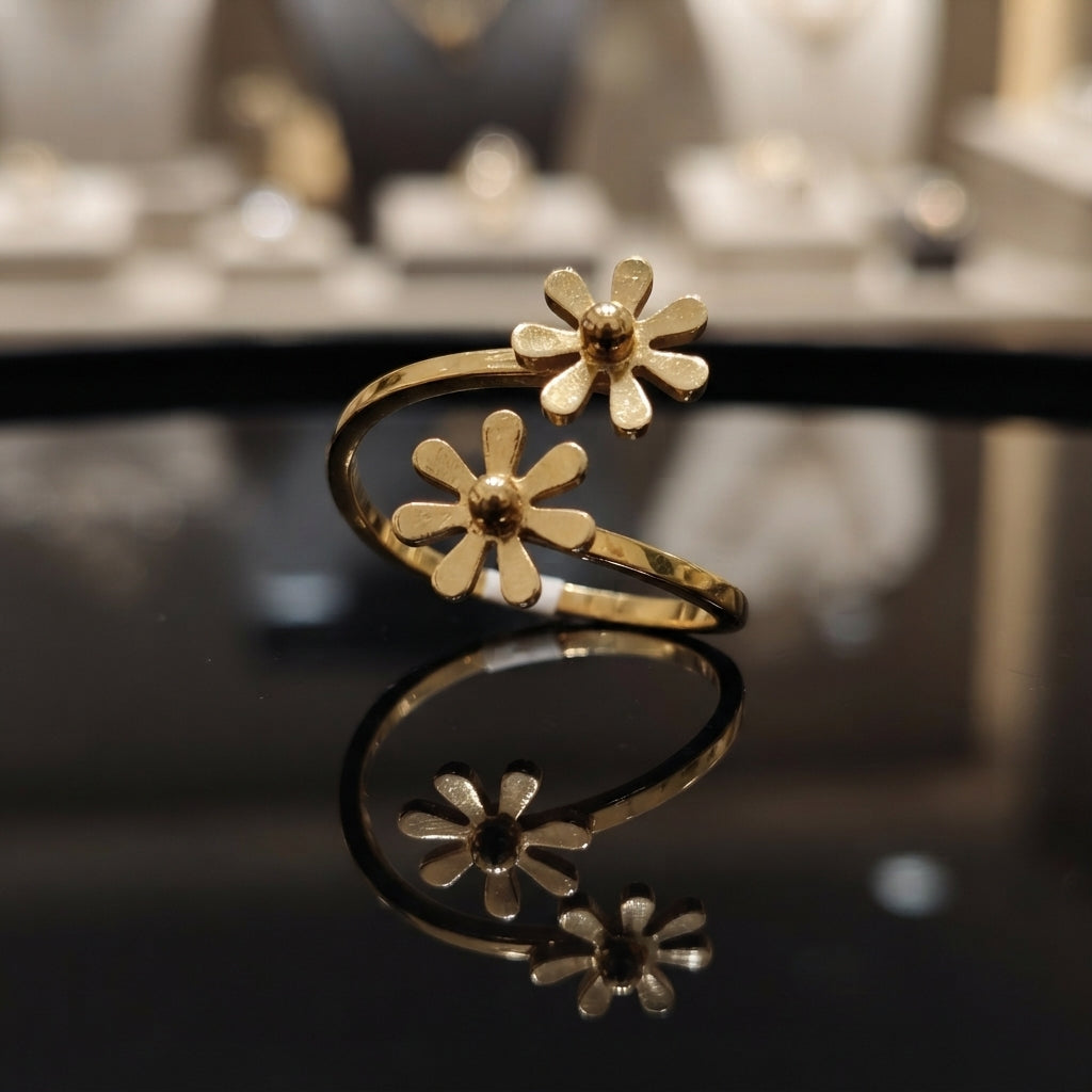 Gold-tone double daisy floral bypass open band ring on reflective surface