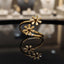 Gold-tone double daisy floral bypass open band ring on reflective surface