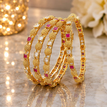 22K Gold-Tone Alternating Ruby & White Square CZ Gold Granule Dome Bead Bridal Bangle Set of 4 stacked on marble surface with gold glitter lantern and white peony flowers backdrop