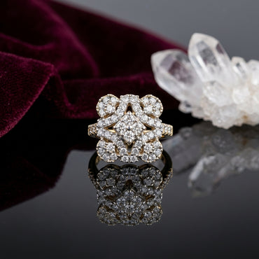 22K Gold-Tone White CZ Quatrefoil Open-Work Cluster & Pavé Shoulder Statement Ring on black mirror surface with deep burgundy velvet fabric and white crystal quartz cluster backdrop