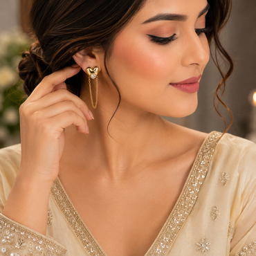 Golden heart-shaped chain drop earrings with sparkling center stones