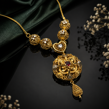 Royal golden filigree pendant necklace with red stone and decorative heart detailing
