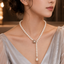 Elegant white pearl Y-drop necklace with floral centerpiece and hanging pearl detail