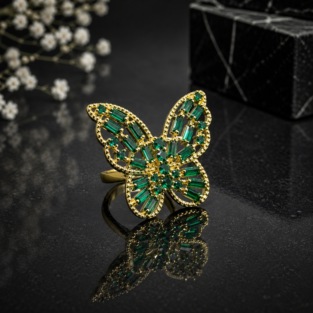 Elegant gold green butterfly statement ring with emerald-green baguette stones and intricate sparkling detailing
