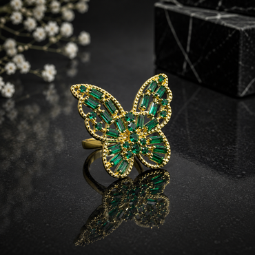 Elegant gold green butterfly statement ring with emerald-green baguette stones and intricate sparkling detailing