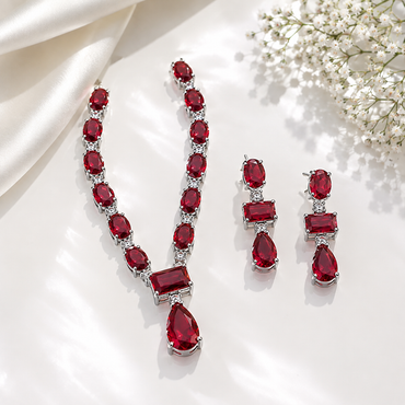 Elegant ruby red CZ necklace and matching earrings set with sparkling clear stones in a luxurious silver-tone design