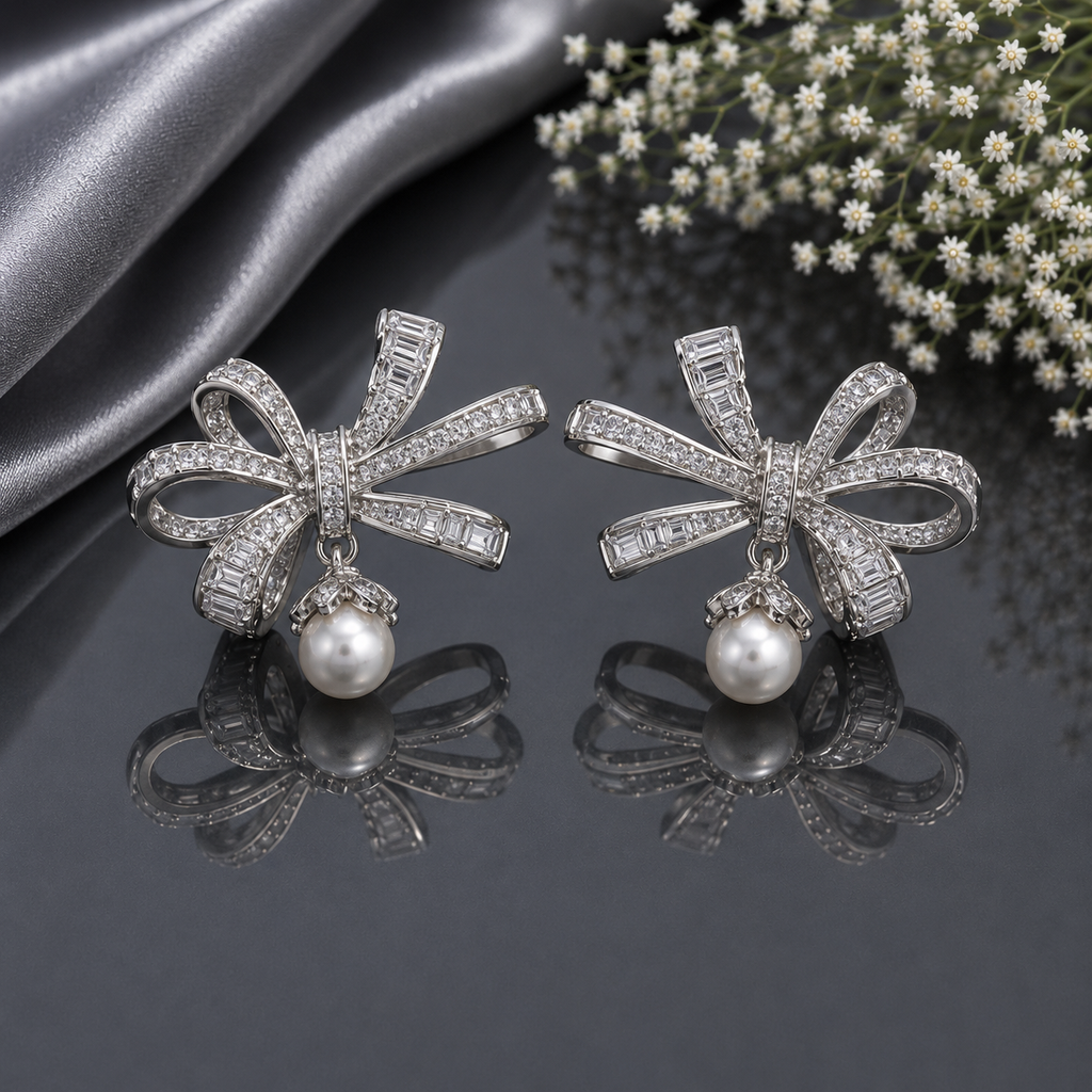 Elegant silver CZ bow pearl drop earrings featuring sparkling clear stones, baguette detailing and luminous pearl drops