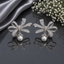 Elegant silver CZ bow pearl drop earrings featuring sparkling clear stones, baguette detailing and luminous pearl drops