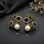 Elegant gold-tone crystal pearl statement earrings with intricate floral detailing and pearl drops