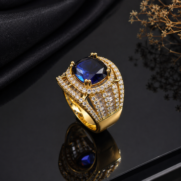 Elegant gold-tone blue CZ statement ring with deep blue center stone and sparkling side detailing