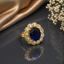 Elegant gold-tone sapphire blue oval halo CZ statement ring with sparkling floral-style detailing