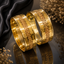 Elegant gold-tone wide bangle set with intricate geometric pattern and polished finish