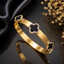 Elegant clover motif bracelet with black floral details and sparkling stone border in gold and silver finishes