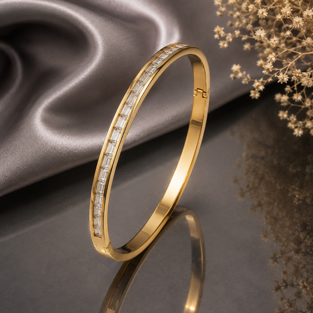 Elegant gold-tone slim bangle with sparkling baguette-cut stone detailing and polished finish