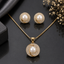 Elegant pearl pendant necklace and matching earrings set with sparkling halo stone detailing