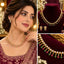 Gold-tone South Indian necklace aur matching earrings with clear, pink and green stones