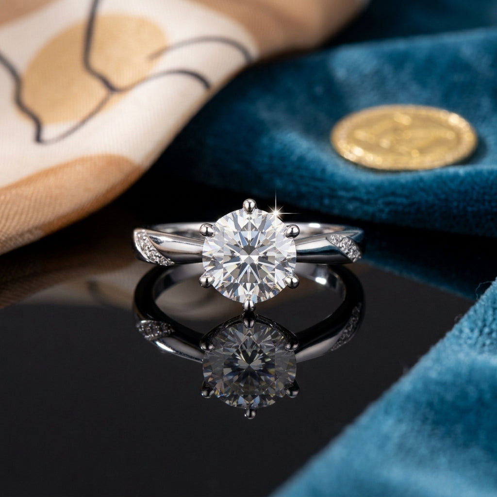 Silver-Tone 6-Prong Round CZ Solitaire & Pavé Shoulder Accent Engagement Ring on black reflective surface with teal blue velvet fabric and gold seal wax stamp backdrop