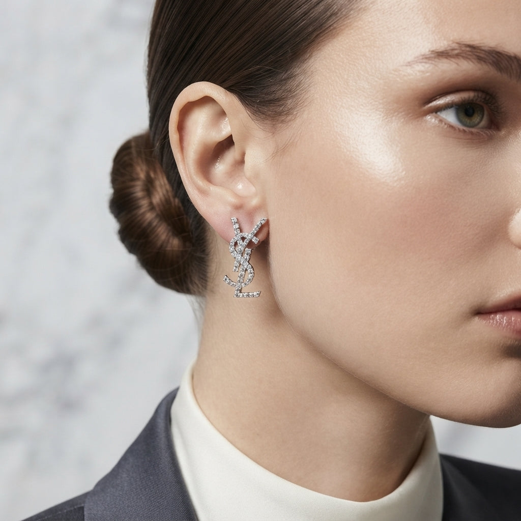 Micro Pavé CZ Monogram Letter Stud Earrings in gold-tone plating worn on model ear with marble background and burgundy blazer showing full CZ encrusted monogram letter design
