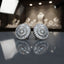 Model wearing round gold-tone cubic zirconia stud earrings with a sunburst halo design.
