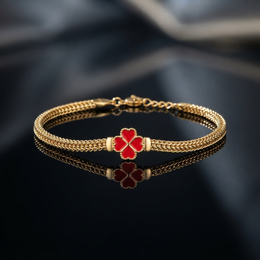 Gold-tone braided bracelet with black four-leaf clover centerpiece