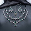 Emerald-green AD bridal jewelry set with layered necklaces, coordinating drop earrings, and maang tikka in a silver-tone finish