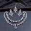 Silver-tone bridal jewelry set with emerald green stones, layered necklaces, matching drop earrings, and forehead ornament