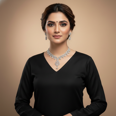 Woman wearing a black outfit with a diamond necklace against a beige background