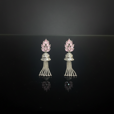 Pair of earrings with pink floral tops and silver bases on a black background