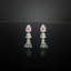 Pair of earrings with pink floral tops and silver bases on a black background