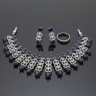 Jewelry set including necklace, earrings, and ring on a reflective surface