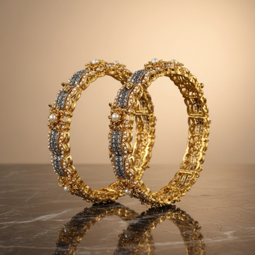 Pair of gold bangles with blue stones on a reflective surface