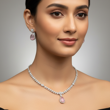 Woman wearing a diamond necklace with pink gemstones against a neutral background