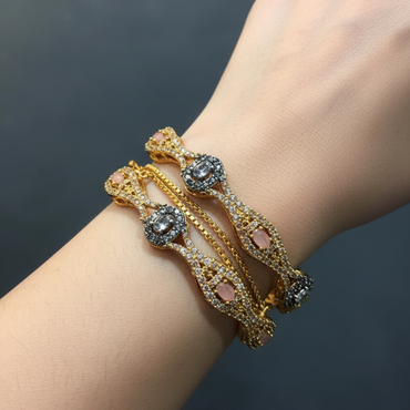 Gold bracelet with gemstones on a wrist against a dark background