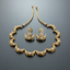 Gold necklace and earrings set on a reflective surface