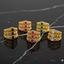 Set of gold rings with gemstones on a dark marble surface