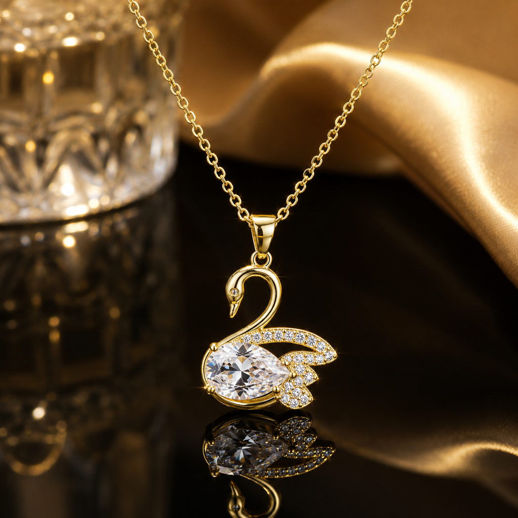 Gold-tone CZ swan pendant necklace with pear-cut white cubic zirconia body and pave wing accents on a cable chain