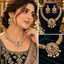 Gold-tone bridal necklace and matching drop earrings with a green center stone, clear accents, and pearl-style dangles