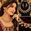 Gold-tone bridal necklace and matching earrings with red and green stones, clear accents, and pearl-style drops