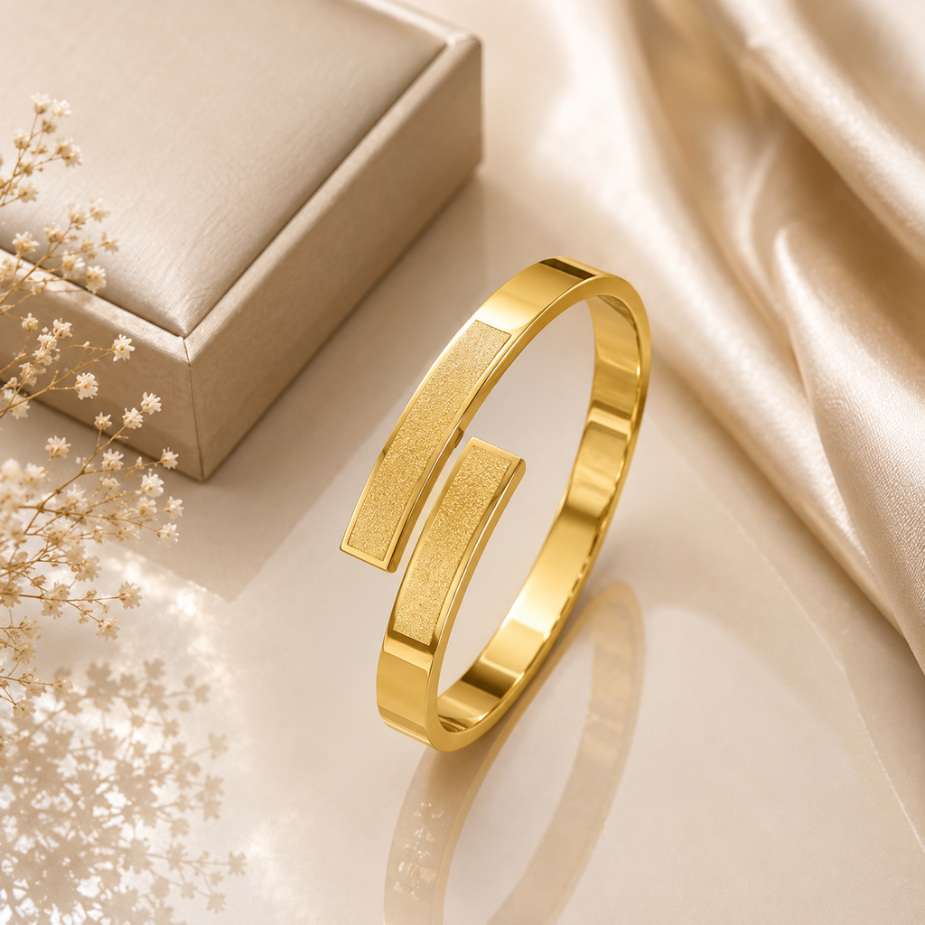 Gold-tone dual bar matte sandblasted and polished open cuff bangle with slim band and two rectangular bar ends displayed on champagne satin with jewelry gift box and dried white flowers