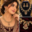 Gold-tone necklace with red and green accents, clear sparkling details, pearl-style drops, and matching drop earrings