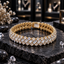 Gold-tone linked bracelet with diagonal clear rectangular accents, round clear accents along both borders and a rectangular back closure section on dark slate.