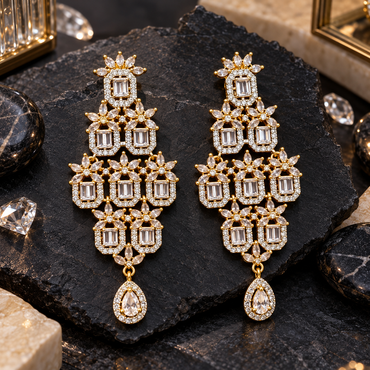 Pair of gold-tone tiered chandelier earrings with rectangular clear centre accents, halo borders, marquise-shaped flower motifs and teardrop bottom drops.