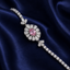 Pink CZ oval sunflower halo tennis bracelet with ring connector in silver-tone featuring large blush pink oval CZ center pear-cut white CZ halo and round CZ tennis chain displayed on navy satin