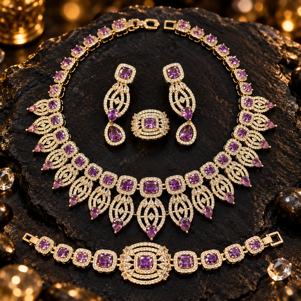 Purple and gold-tone jewellery set featuring an ornate necklace, matching drop earrings, bracelet and ring with clear sparkling details.